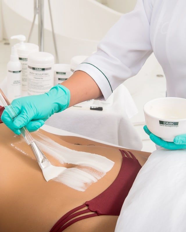 image of woman applying enzyme treatment to clients stomach
