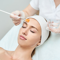 image of women applying facial peel to face of client